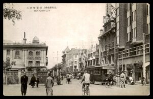 לוט 69 – גלויה עתיקה "עיר טיאן צ'ין" – רחוב מרכזי עם חשמלית, סין, עם חותמת עברית | Lot 69 – Vintage Postcard "Tien Chin City" – Busy Street with Tram, China, with Hebrew Stamp